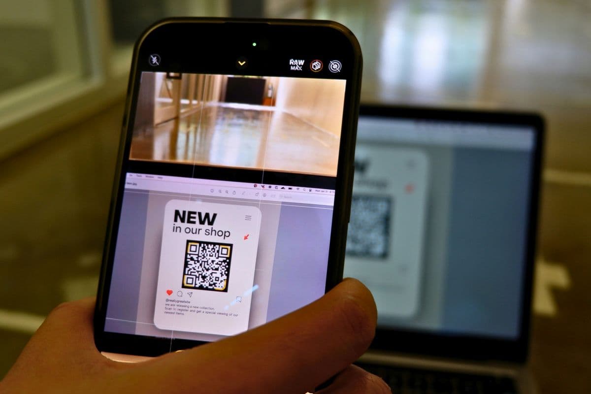 a person holding a cell phone in front of a laptop